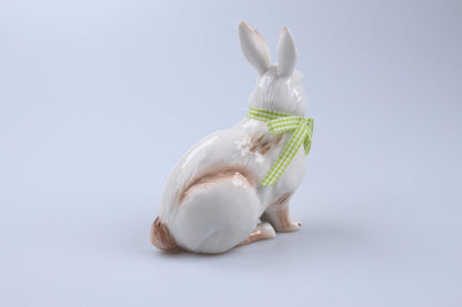 Osterhase sitzend mit grüner Schleife